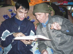 Jurturi külla tõi raamatud Artjom (vasakul). Vanataat rõõmustab, et suurte tähtedega U Sugõni saab lugeda prillideta. Foto: Anu Väliaho